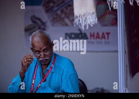 Noida, Inde - Fév 2023: Noida Haat, Portrait d'un ancien commerçant participant à Noida haat pour démontrer les produits artisanaux fabriqués à la main. Banque D'Images