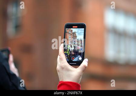 Les fans voient l'arrivée de l'entraîneur de l'équipe par téléphone mobile, pays de Galles contre Angleterre six Nations - pré-match accumulation à Cardiff, 25th février 2023 Banque D'Images