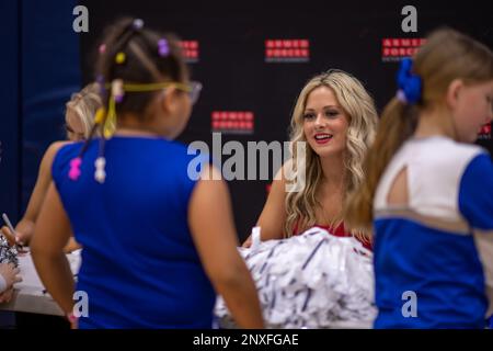 Michelle Harvey, une meneuse avec les Los Angeles Rams, signe des cartes pour les enfants de la Marine corps Air Station Iwakuni pendant la Pro Blitz Cheer Clinic sur MCAS Iwakuni, Japon, 12 février 2023. La tournée Blitz Pro de divertissement des Forces armées permet aux membres du service déployés à l'avance et à leurs familles de rencontrer les meneurs et les joueurs de la Ligue nationale de football. Banque D'Images