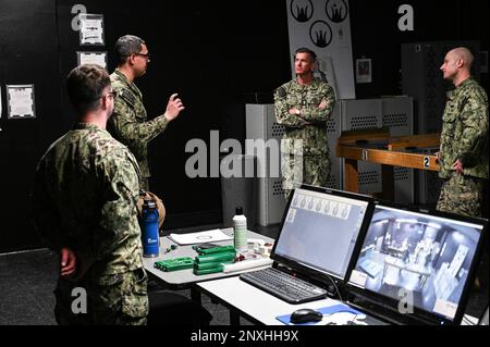 GREAT LAKES, Illinois (23 février 2023) le chef de la Force, Jason Knupp, à droite, en poste au sein de la Force navale de surface de l'Atlantique, reçoit les commentaires de Darold W. Maki, un instructeur du Commandement de l'entraînement des systèmes de combat de surface des Grands Lacs, Dans le simulateur MILO de l'école Mate 'A' de Gunner lors d'une visite aux sites de formation d'accession à la station navale des Grands Lacs. La visite comprenait des installations de tourisme et des marins des écoles de NETC pour la guerre de surface, les systèmes de combat et la défense des victimes à bord des navires, y compris l'observation des dernières méthodes d'entraînement modernisées pour les exercices pratiques prêts Banque D'Images