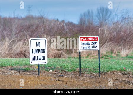 Photo horizontale d'un panneau « aucun vidage autorisé » et d'un panneau « Avertissement : caméras de sécurité en cours d'utilisation » dans un champ. Banque D'Images