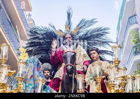 Le Christ est à cheval sur un âne dans le trône ou sur la plate-forme de la Fraternité de la Borriquita, en procession par les rues étroites de la ville Banque D'Images