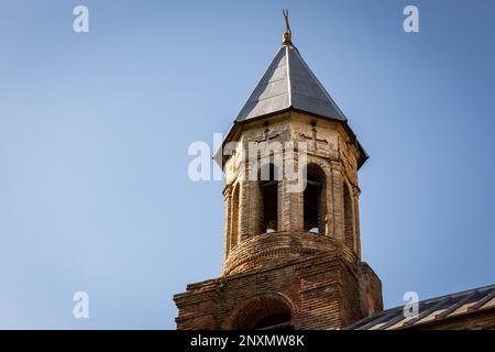 Ancien clocher médiéval (beffroi) contre le ciel bleu, église de Saint-Georges à Surami, Géorgie, construit de briques brunes et de dômes avec des silres. Banque D'Images