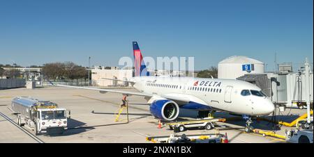 Austin, Texas - février 2023 : l'Airbus A220 de Delta Air Lines (immatriculation N144DU) est ravitaillé à l'aéroport de la ville. Banque D'Images