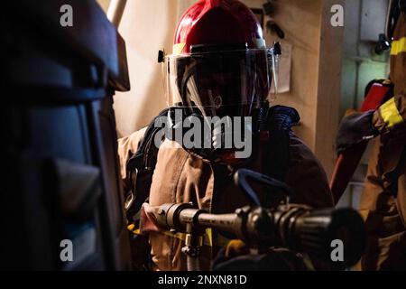 Le pompier Joseph, affecté au quai de transport amphibie de classe San Antonio USS Arlington (LPD 24), combat un incendie simulé lors d'un exercice de construction de quartiers généraux en cours dans l'océan Atlantique, le 10 février 2023. Les marins d'Arlington maintiennent la maîtrise des dommages en effectuant des exercices de routine à la fois à l'intérieur et en cours. Banque D'Images