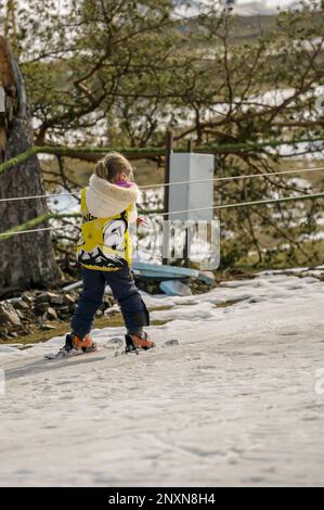 Une fille à skis monte le téléphérique Banque D'Images