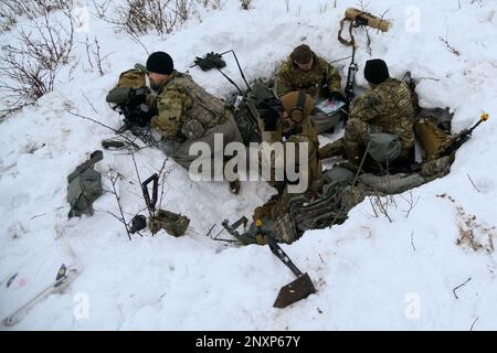 Une équipe de 1-120th observateurs de l'avant du Régiment d'artillerie de campagne a localisé des cibles et a appelé à l'incendie pendant la grève du Nord 23-1, le 23 janvier 2023, au Camp Grayling, Michigan. Les unités qui participent à la phase d’hiver de la grève du Nord sont prêtes en menant une formation conjointe par temps froid conçue pour atteindre les objectifs de la Stratégie pour l’Arctique du ministère de la Défense. Banque D'Images