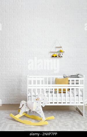 Intérieur de la chambre des enfants avec lit de bébé et cheval à bascule Banque D'Images