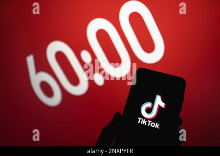 TikTok définit une limite d'une heure pour les utilisateurs de moins de 18 ans. Logo de l'application Tik Tok sur le téléphone à côté de 60 minutes de texte en arrière-plan. Swansea, Royaume-Uni - 1 mars 2023. Banque D'Images