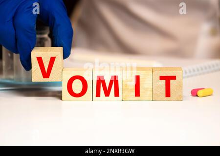 vomit mot écrit sur bloc de bois. vomit texte sur table en bois pour votre desing, concept de coronavirus vue de dessus. Banque D'Images