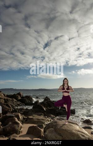 Trouvez votre paix intérieure : femme blonde pratiquant le yoga sur la plage Banque D'Images