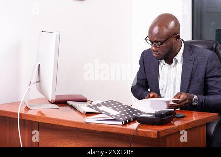 portrait d'un homme d'affaires concentré travaillant dans le bureau tout en vérifiant les notes dans le document. Banque D'Images