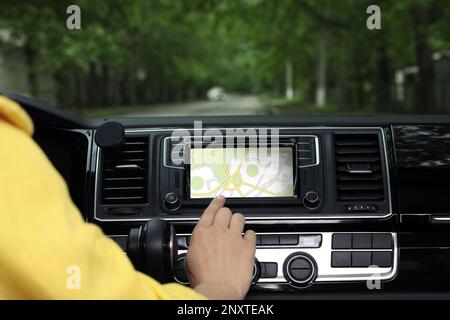 Femme utilisant le système de navigation en conduisant une voiture, en gros plan Banque D'Images