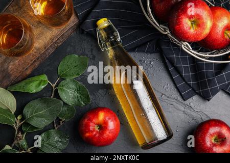 Composition de la couche plate avec un délicieux cidre de pomme sur une table noire Banque D'Images