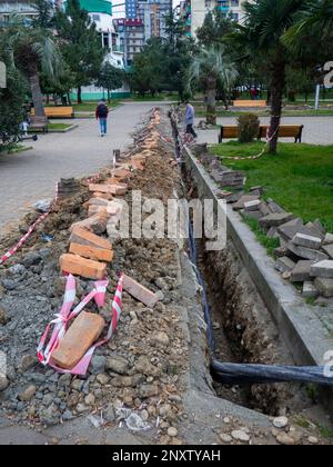 Trottoir brisé. Conduite du câble sous terre. Pose de câbles. Communications dans la ville. Électrification. Creuser une tranchée pour les fils. Banque D'Images