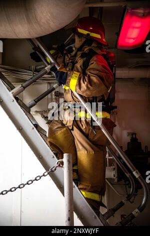 Spécialiste du personnel 2nd classe Juliette Parissi, affectée au navire de transport amphibie de classe San Antonio USS Arlington (LPD 24), décale un ladderwell lors d'un forage de quartiers généraux en cours dans l'océan Atlantique, le 10 février 2023. Les marins d'Arlington maintiennent la maîtrise des dommages en effectuant des exercices de routine à la fois à l'intérieur et en cours. Banque D'Images