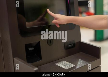 Femme sans visage utilisant l'écran tactile ATM. Banque D'Images