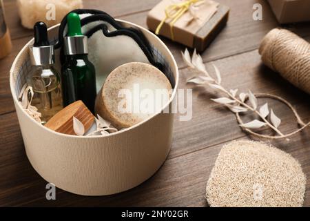 Boîte avec produits de salle de bain écologiques sur table en bois Banque D'Images