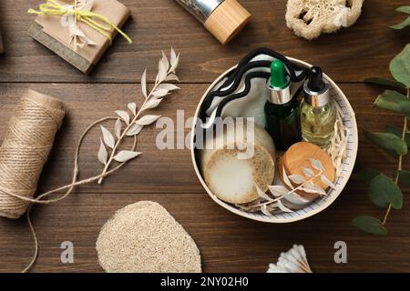 Boîte avec produits de salle de bain écologiques sur table en bois, plat Banque D'Images