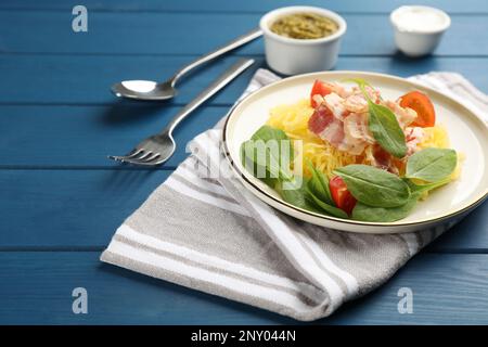 Courge spaghetti savoureuse au bacon et au basilic servi sur une table en bois bleu, espace pour le texte Banque D'Images