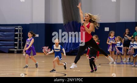 Michelle Harvey, une meneuse avec les Los Angeles Rams, présente des échauffements à l'étage pour les enfants de la Marine corps Air Station Iwakuni pendant la Pro Blitz Cheer Clinic sur MCAS Iwakuni, Japon, 12 février 2023. La tournée Blitz Pro de divertissement des Forces armées permet aux membres du service déployés à l'avance et à leurs familles de rencontrer les meneurs et les joueurs de la Ligue nationale de football. Banque D'Images