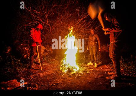 Naplouse, Palestine. 01st mars 2023. Des Palestiniens masqués portant des bâtons de bois autour du feu se tiennent sur garde pendant la nuit pour repousser les attaques des colons juifs, au sud de Naplouse, en Cisjordanie. Les attaques de colons se sont intensifiés contre les Palestiniens, en particulier les villages au sud de Naplouse, comme Hawara Burin, le dernier d'entre eux a été sur la ville de Hawara, dont les dommages ont été causés par l'incendie de dizaines de maisons et de boutiques et plus d'une centaine de voitures. Le Premier ministre palestinien Muhammad Shtayyeh a déclaré que les pertes totales étaient estimées à près de $5 millions. Crédit : SOPA Images Limited/Alamy Live News Banque D'Images