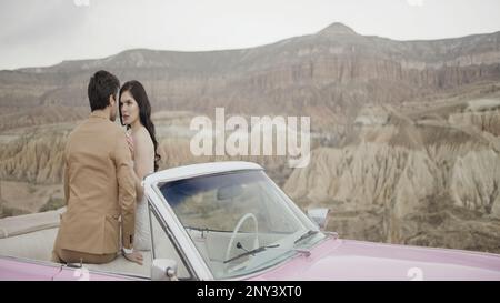 Belle séance photo histoire d'amour. Action.Un jeune couple dans la nature en costumes sont photographiés sur fond de montagnes avec le temps chaud. Hin Banque D'Images