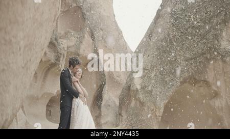 Belle séance photo histoire d'amour. Action.Un jeune couple dans la nature en costumes sont photographiés sur fond de montagnes avec le temps chaud. Hin Banque D'Images