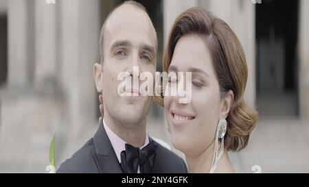 Photographie de mariage dans les lieux touristiques. Action. Un beau couple en costumes intelligents marchant autour de la place et posant pour la caméra. Haute qualité 4K Banque D'Images