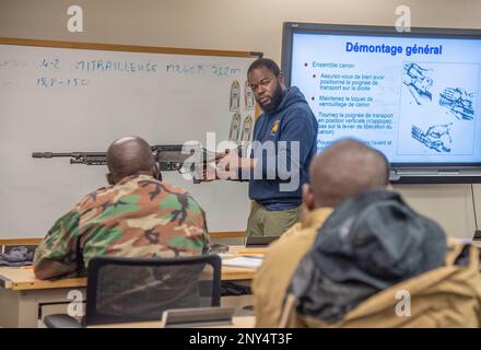 Le capitaine Abdoul Aziz Moumouni, un instructeur de la nation partenaire (PNI) de l'école navale d'instruction et de formation technique pour les petits bateaux (NAVSCIATTS), donne des instructions pendant un cours d'officier de patrouille fluvial (PCOR) sur la façon de démonter et de remonter correctement une mitrailleuse M240B sur le centre spatial John C. Stennis, au Mississippi, au 6 février 2023. Moumouni est aussi traducteur français pendant les États-Unis de l'école Commandement de l'Afrique Banque D'Images