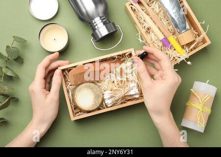 Femme avec produits de salle de bain écologiques sur fond vert, vue de dessus Banque D'Images