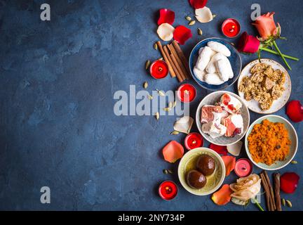 Cadre festif indien de Diwali avec des bonbons traditionnels. Gulab jamun, carotte halwa, encas aux bougies, fleurs. Assortiment de desserts indiens. Banque D'Images