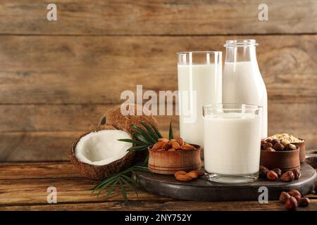 Différents laits et ingrédients végétaliens sur une table en bois. Espace pour le texte Banque D'Images