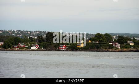 Paysage naturel avec rivière ondulée et maisons au bord de la côte. Action. Campagne, vue sur la rivière sur une petite ville et arbres verts Banque D'Images