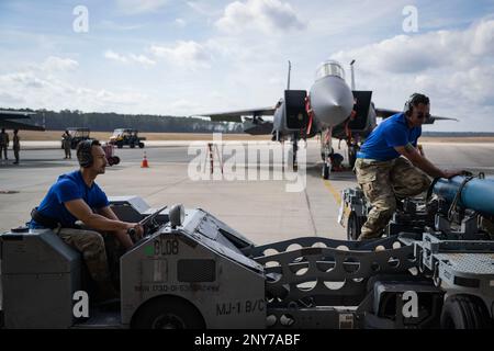 Ancien Airman Daniel Gomez, 334th Fighter Generation Squadron, membre de l'équipage de chargement de trois hommes, à gauche, Et le sergent d'état-major Jovany Rodriguez, chef d'équipe de chargement d'armes FGS 334th, se prépare à charger une arme sur un aigle de frappe F-15E lors d'une compétition d'équipage de chargement d'armes de l'année à la base aérienne Seymour Johnson, en Caroline du Nord, le 10 février 2023. Les compétitions d'équipage de charge préparent les aviateurs à des opérations rapides qu'ils peuvent rencontrer pendant leur déploiement. Banque D'Images