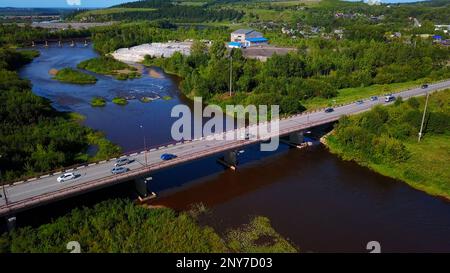 Vue Arial d'une petite ville traversée par une rivière avec un pont. Attache. Lieu écologique, vivant à la campagne Banque D'Images