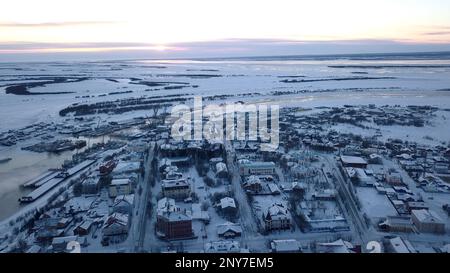 Vue aérienne d'une grande ville avec des toits couverts de neige. Attache. Vol au-dessus de la ville gelée et d'une rivière Banque D'Images