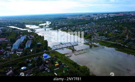 Vue Arial d'une petite ville traversée par une rivière avec un pont. Attache. Lieu écologique, vivant à la campagne Banque D'Images