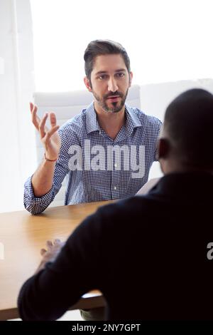 Parlez-moi de votre expérience professionnelle précédente. un homme d'affaires qui interviewe un candidat à un emploi dans un bureau. Banque D'Images