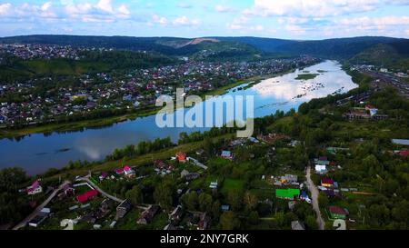 Vue Arial d'une petite ville traversée par une rivière avec un pont. Attache. Lieu écologique, vivant à la campagne Banque D'Images