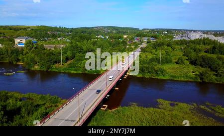 Vue Arial d'une petite ville traversée par une rivière avec un pont. Attache. Lieu écologique, vivant à la campagne Banque D'Images