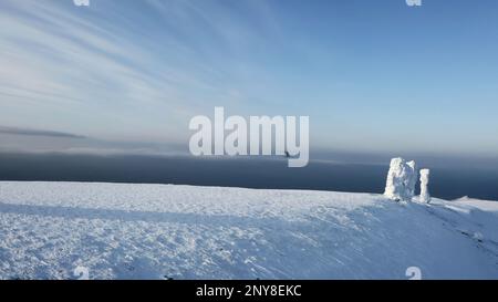 Vue aérienne sur les blocs de pierre enneigés et la vallée blanche. Attache. Manpupuner en hiver sur fond bleu ciel Banque D'Images