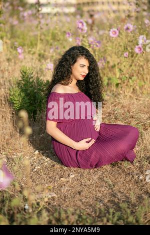 Femme enceinte assise à l'extérieur Banque D'Images