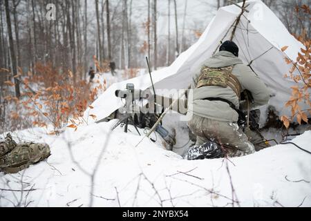 Le SPC Brandon Negrete, un medic affecté aux observateurs avant du 1-120th Field Artillery Regiment, réagit à une attaque simulée lors de la grève du Nord 23-1, le 24 janvier 2023, au Camp Grayling, au Michigan. Les unités qui participent à la phase d’hiver de la grève du Nord sont prêtes en menant une formation conjointe par temps froid conçue pour atteindre les objectifs de la Stratégie pour l’Arctique du ministère de la Défense. Banque D'Images