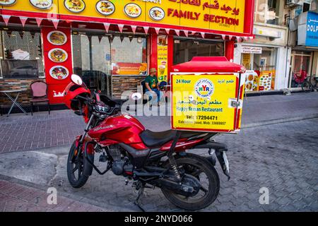 Une moto de livraison de nourriture du restaurant Happy Yeman garée devant son point de vente à Manama, Royaume de Bahreïn, Moyen-Orient. Banque D'Images