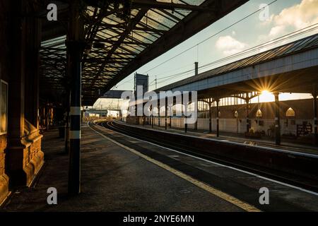 Plates-formes vides et voies ferrées sur la West Coast main Line au coucher du soleil Penrith North Lakes station, Penrith Cumbria Banque D'Images