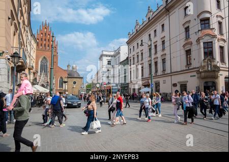 Vue sur les principales rues centrales avec des bâtiments anciens, boutiques haut de gamme, restaurants et cafés à Cracovie, Pologne. Banque D'Images