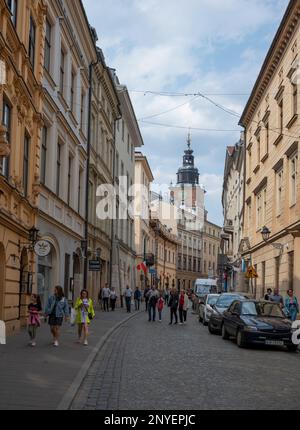 Vue sur les principales rues centrales avec des bâtiments anciens, boutiques haut de gamme, restaurants et cafés à Cracovie, Pologne. Banque D'Images