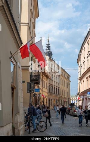 Vue sur les principales rues centrales avec des bâtiments anciens, boutiques haut de gamme, restaurants et cafés à Cracovie, Pologne. Banque D'Images