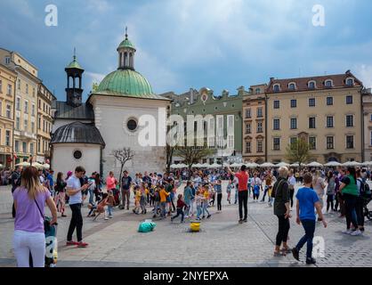 Vue de Rynek Glowny, la place du marché principale avec des bâtiments historiques, des monuments, une salle de tissu, une basilique et des magasins à Cracovie, Pologne. Banque D'Images